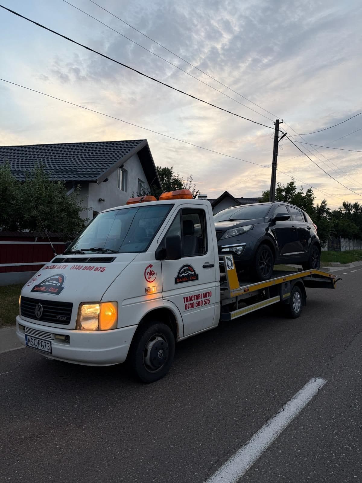 Platforma de tractari DCB Auto Garage la apus, pe un drum din judetul Suceava