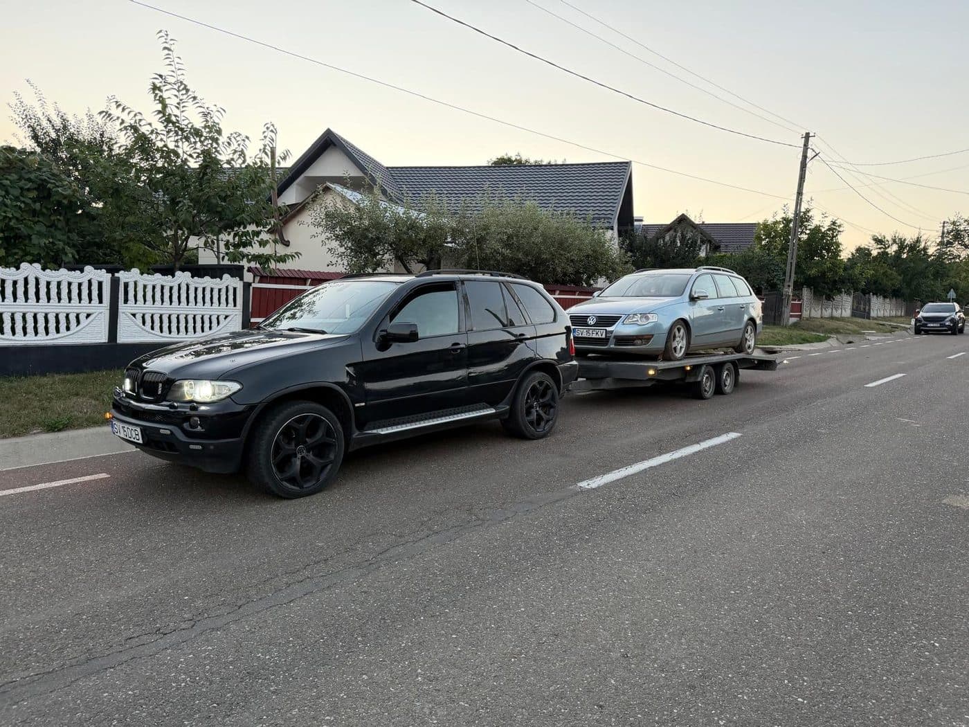 Autoturism ridicat pe platforma de tractare pe o strada din oras